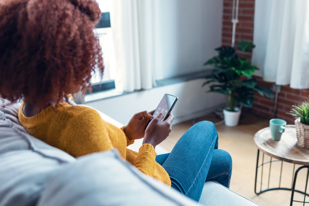 woman checking phone on couch