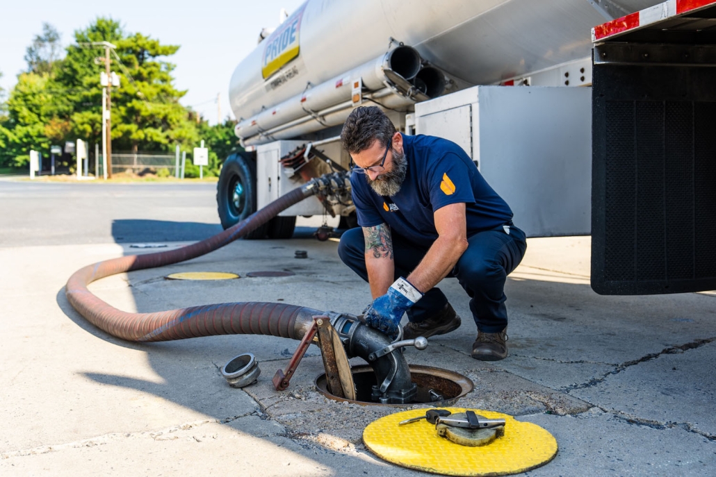 employee filling tank at gas station
