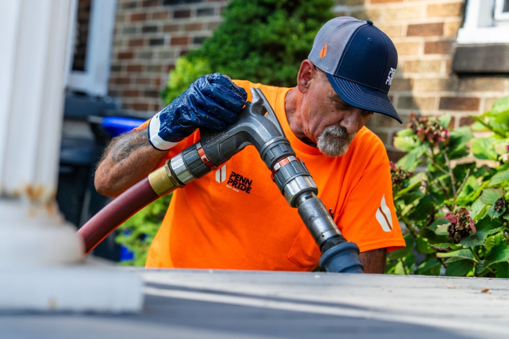employee holding a hose filling up a tank