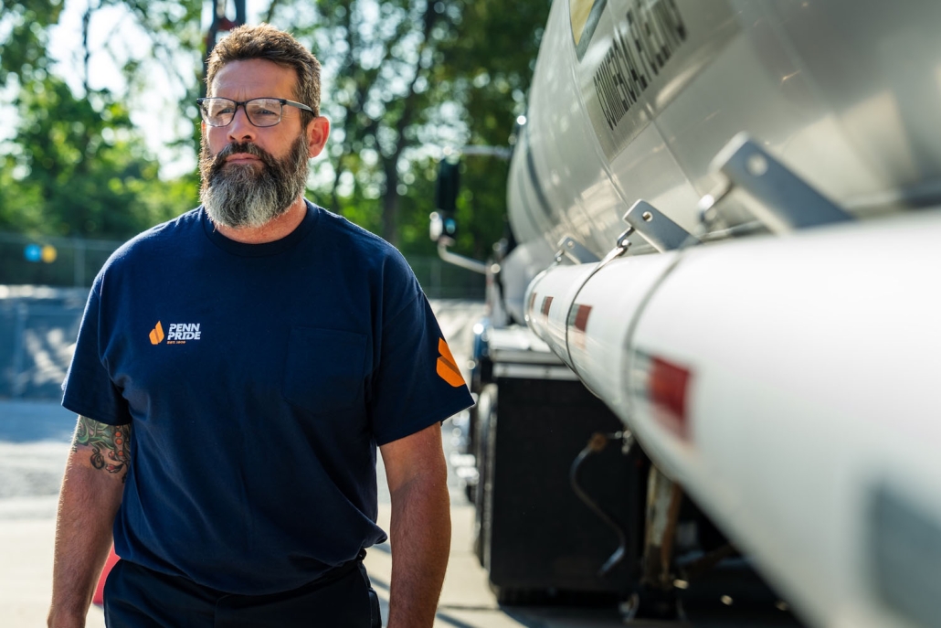 delivery driver standing next to fuel truck